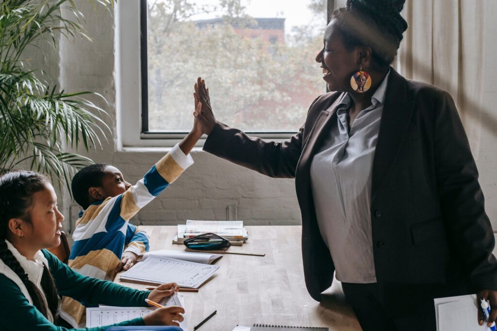 Confident educator standing in front of classroom high fives