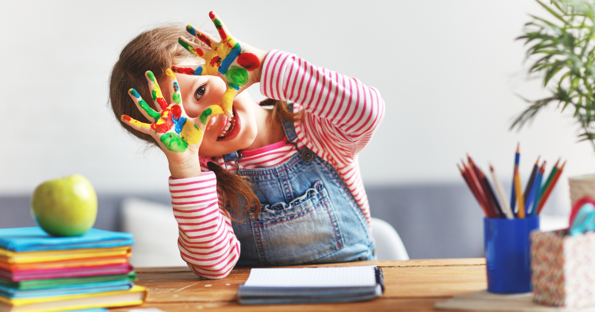 child with paint on their hands, part of IEP process
