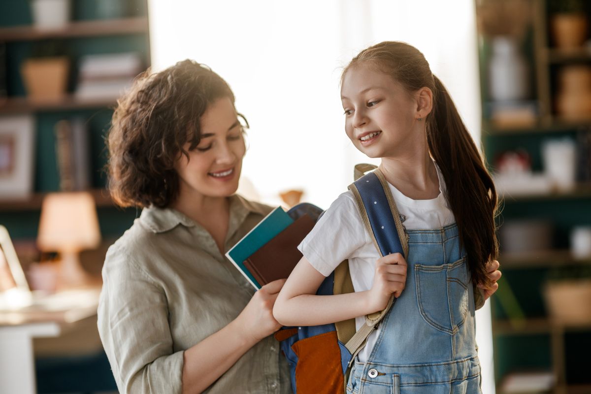 parent helping child with backpack